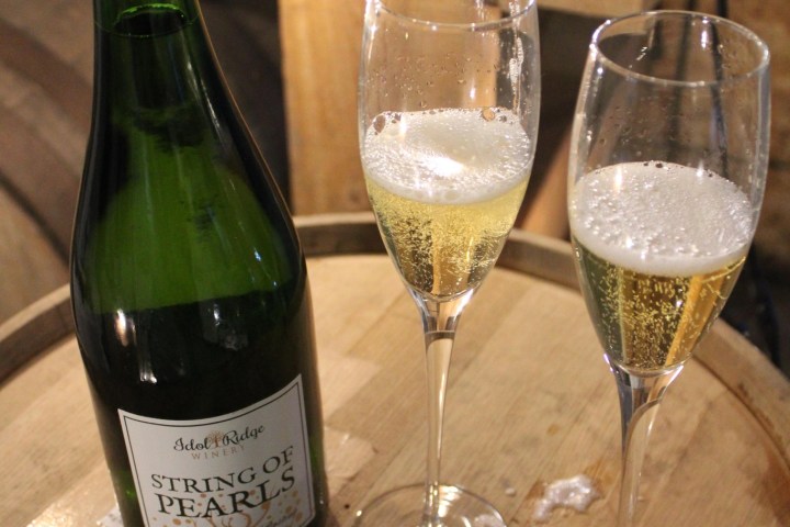 a bottle of wine glasses sitting on a table