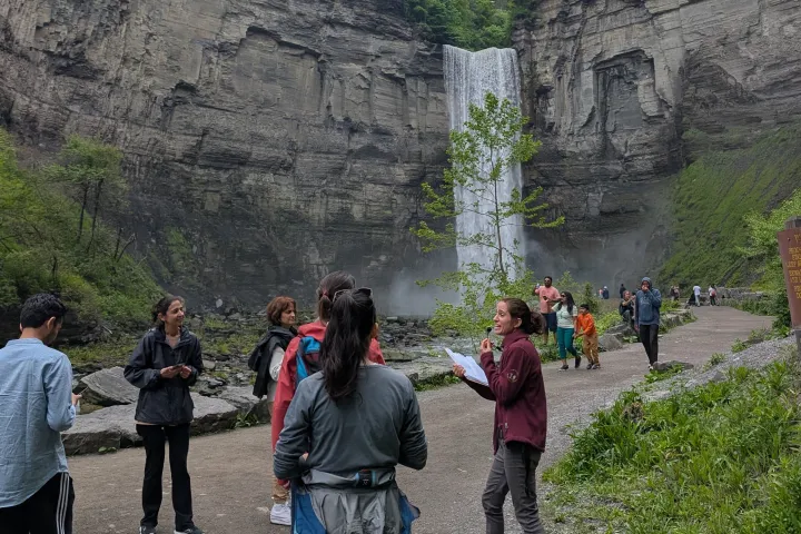 a group of people standing in front of a mountain