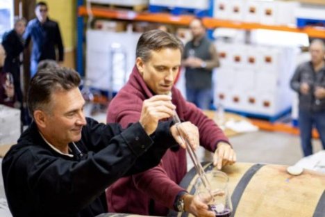 sampling wine from a barrel