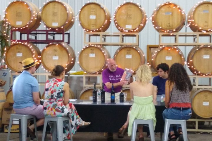 a group of people sitting at a table with wine tasting