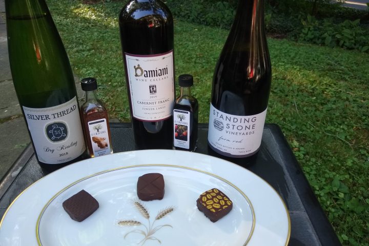 a close up of a plate of chocolates and bottles of wine