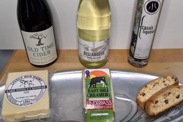 a bottle of wine, cider and liqueur with cheese and biscotti