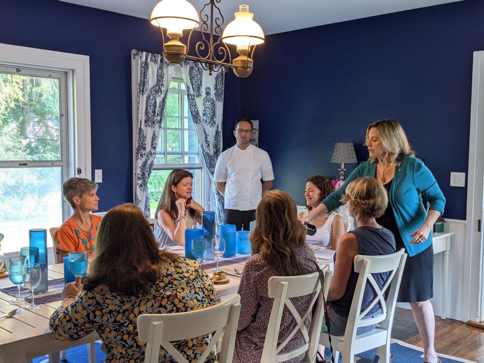 a group of people sitting at a table in front of a window