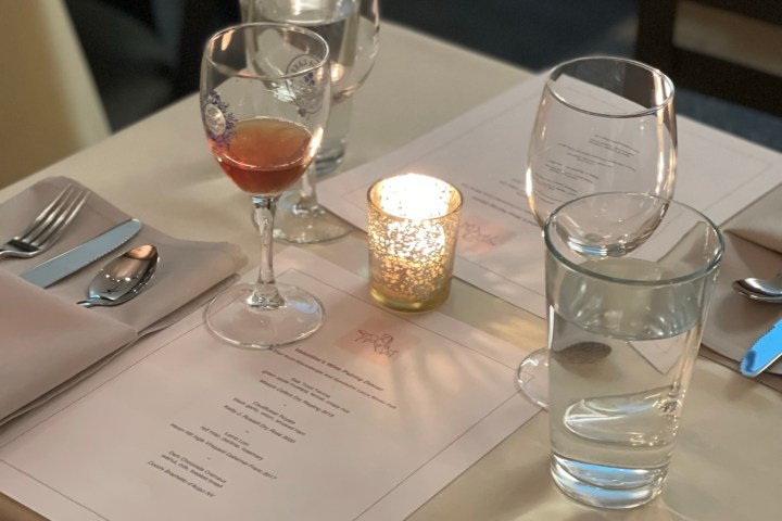 a glass of wine sitting on top of a table