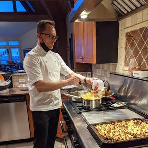 a man and woman preparing food in a kitchen