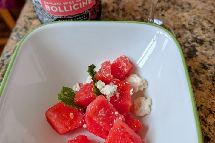 a close up of a plate of food on a table with wine