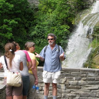 a group of people standing next to a stone wall