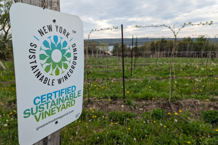 a sign on the side of a grass covered field