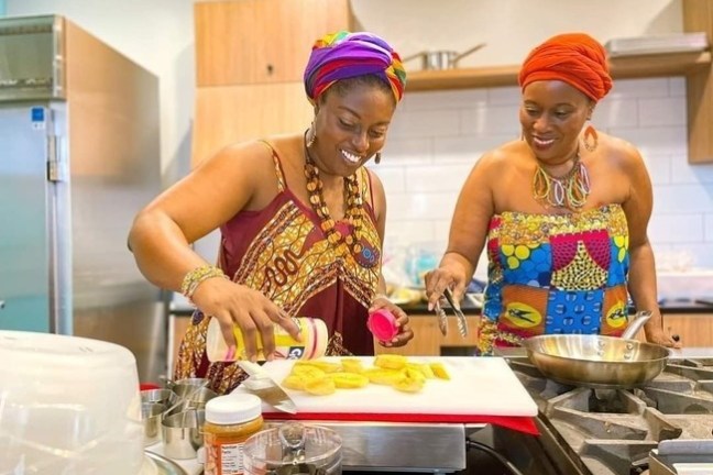 a man and woman preparing food in a kitchen